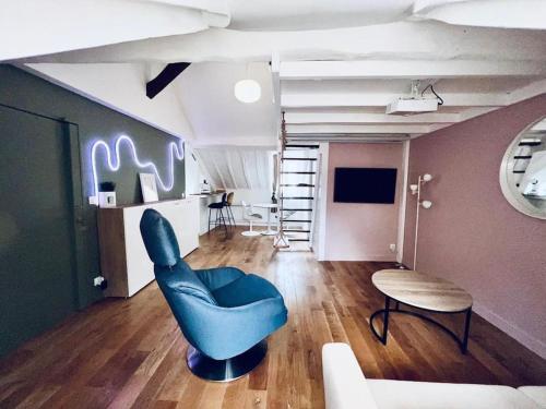 a living room with a blue chair and a table at Lovely flat 20min from Champs Élysée, 10min from Stade de France in Saint-Denis