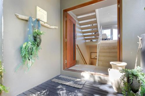 a hallway with a door and stairs with plants at Unit 9 Fantastic Holiday Apartment in Sunshine Beach Stunning Views Opposite Beach Access in Sunshine Beach