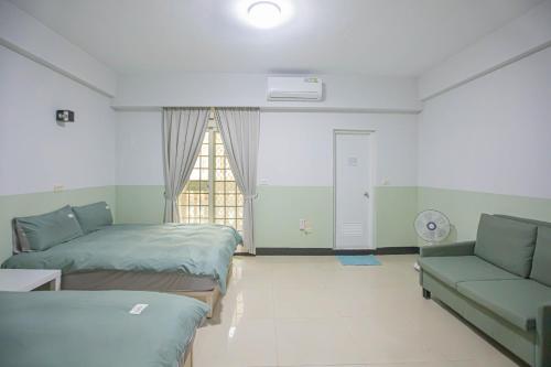 a room with two beds and a couch and a window at 卡薩行旅二館 包棟民宿 in Hsia-hsing