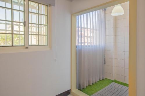 ein Bad mit einer Dusche und einem Fenster in der Unterkunft 卡薩行旅二館 包棟民宿 in Hsia-hsing