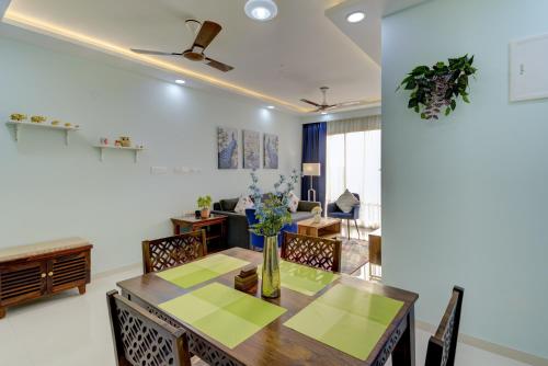 a dining room and living room with a table and chairs at Premium 2BHK apartment with Pool Access in Vasco Da Gama