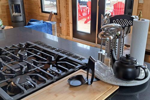 a kitchen stove top with a tea pot on a counter at Islander Lodge - Lochaber Lake Lodges in Antigonish