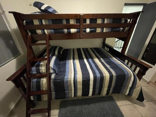 - un lit superposé en bois avec une couverture rayée dans l'établissement Gabbys House in private neighborhood, à Mexicali