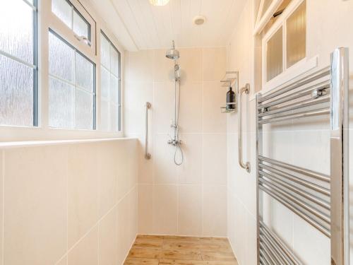 a bathroom with a shower stall and a window at Twegan in Trunch