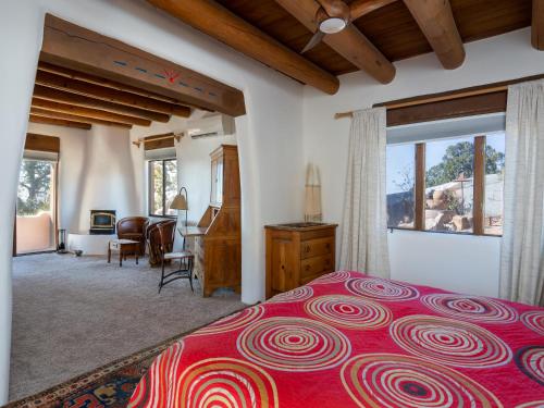 ein Schlafzimmer mit einem großen Bett mit einer roten Tagesdecke in der Unterkunft Casa De Oro in Santa Fe
