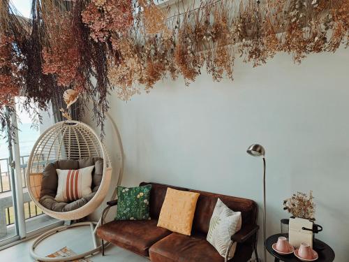 a living room with a couch and a hanging chair at Noosa海岸行館 in Fengbin