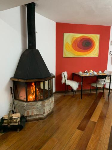 una chimenea en una habitación con una mesa y un cuadro en Hotel e Spa Provençal, en Canela