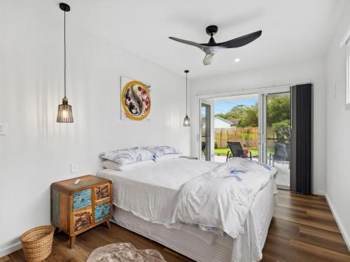 a bedroom with a bed and a ceiling fan at Little Kim Close in Woolgoolga
