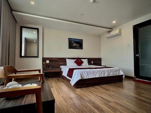 um quarto de hotel com uma cama e uma cadeira em Khách sạn Bảo Linh em Tràm Chim