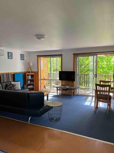a living room with a couch and a tv at Clifton Beach Lodge in Princetown