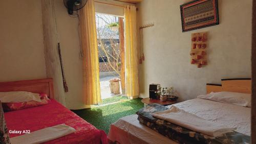 um quarto com 2 camas e uma grande janela em Lưng Đồi Homestay Mộc Châu em Mộc Châu