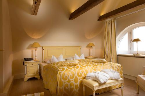 a bedroom with a bed with a yellow comforter at Palais Esplanade Hamburg - Adults Only in Hamburg