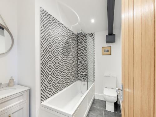 a bathroom with a bath tub and a toilet at Henry House - Uk39786 in Burton in Lonsdale