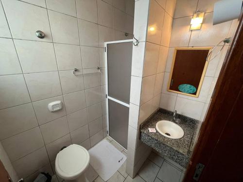 a bathroom with a toilet and a sink at Oscar Palace Hotel - SOB NOVA GESTÃO in Tubarão