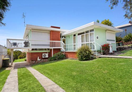 a house with a balcony and a yard at Jack's Place in Gerringong
