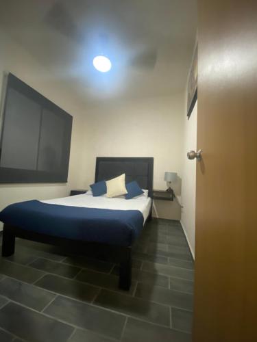 a bedroom with a bed with blue pillows on it at Departamento Ecoface Vallarta in Puerto Vallarta