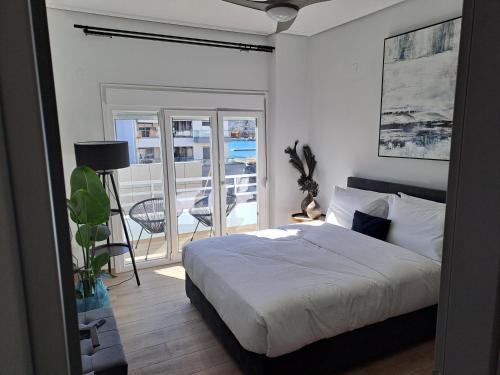 a bedroom with a bed and a balcony at Homing Volos Inspired Modern Living in Volos