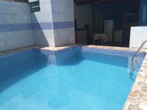 una gran piscina con azulejos azules. en Casa de Praia com Piscina em Mongagua - Disponivel Carnaval en Mongaguá