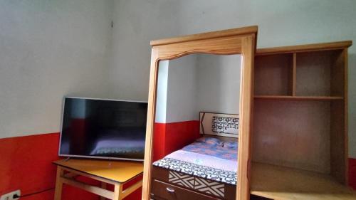 Habitación pequeña con TV y espejo. en Hospedaje Colonial Tarmeño., en Tarma