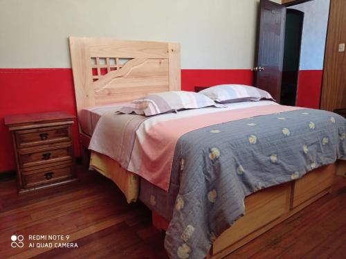 una camera con un grande letto con testiera in legno di Hospedaje Colonial Tarmeño. a Tarma