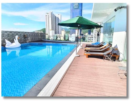 a swimming pool with a swan and an umbrella on a building at FLC Quy Nhon Beach Apt in Quy Nhon