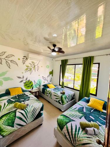 a bedroom with two beds and a ceiling at Oso Perezoso Pool Villa in Puerto Viejo