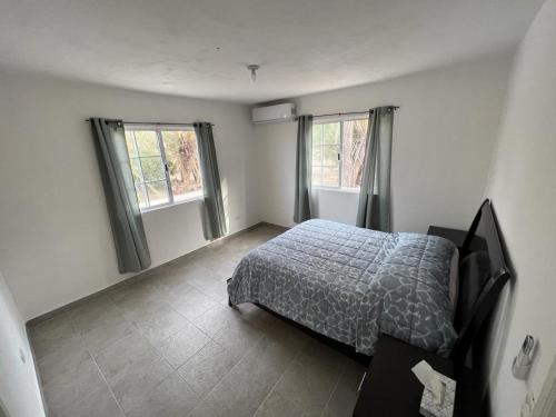 ein Schlafzimmer mit einem Bett und zwei Fenstern in der Unterkunft Gina House with Pool in Mulege in Mulegé