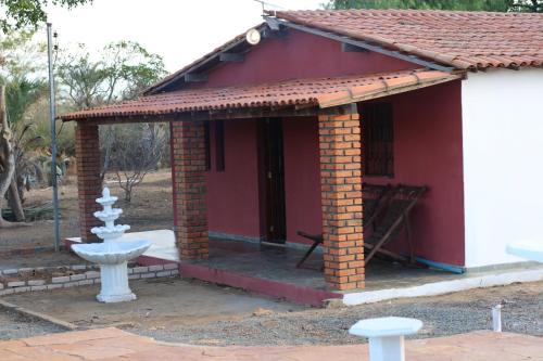 a small red building with a fountain in front of it at Sítio Mandacaru na Chapada Diamantina in Seabra