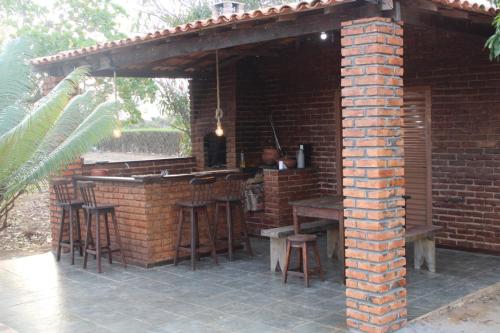 a brick bar with stools and a man sitting at it at Sítio Mandacaru na Chapada Diamantina in Seabra