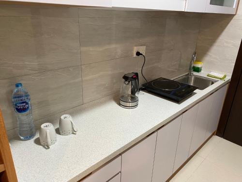 a kitchen counter with a stove and a sink at Formosa Spacious Apartments with Netflix & Pick Up Service by MESA in Nagoya