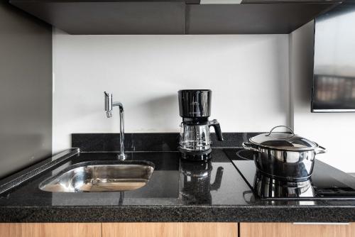 a kitchen counter with a sink and a mixer at Kaza Noah VN Ueno Bela Vista in Sao Paulo