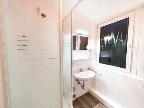 a bathroom with a sink and a glass shower at City Hotel West in Frankfurt