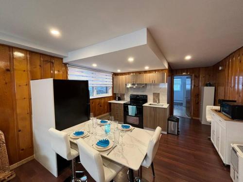 a kitchen with a white table and white chairs and a kitchen with a kitchen at Cozy Spacious Work Friendly Lotus with Garden View High speed free Wi Fi and Parking Adjacent to Downtown Montreal in Montreal