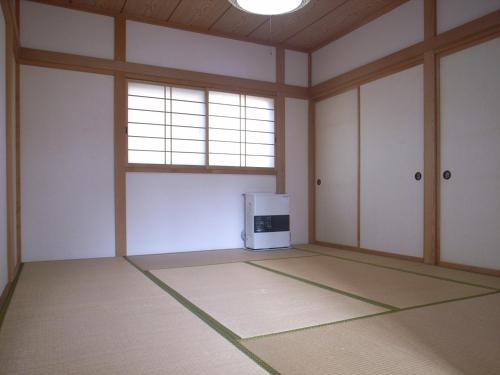 una stanza vuota con forno a microonde e finestra di Cottage All Resort Service / Vacation STAY 8371 a Inawashiro