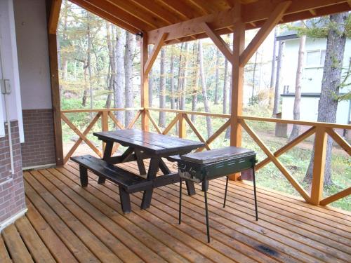 un portico in legno con tavolo da picnic e panche di Cottage All Resort Service / Vacation STAY 8371 a Inawashiro