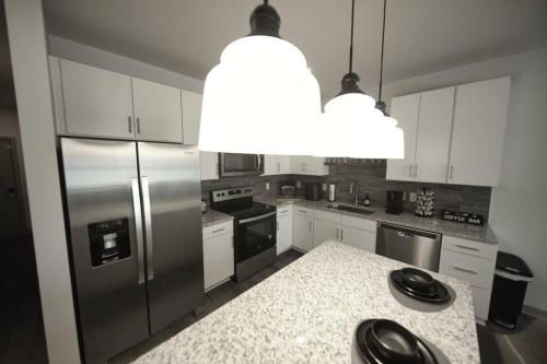 a kitchen with a stainless steel refrigerator and white cabinets at Optimum - Groovy Sanctuary! in Birmingham