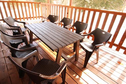 uma mesa de madeira e cadeiras num deque em Cottage All Resort Service / Vacation STAY 8407 em Inawashiro
