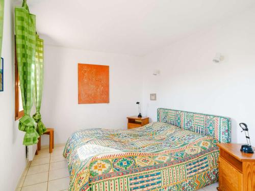 - une chambre avec un lit doté d'un couvre-lit coloré dans l'établissement **Villa 4 pièces pour 7 avec piscine, proche plage, Gruissan** - FR-1-409-90, à Gruissan