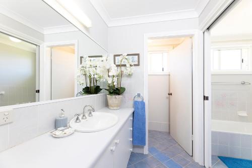 a white bathroom with a sink and a mirror at Lakeview Lodge in Forster