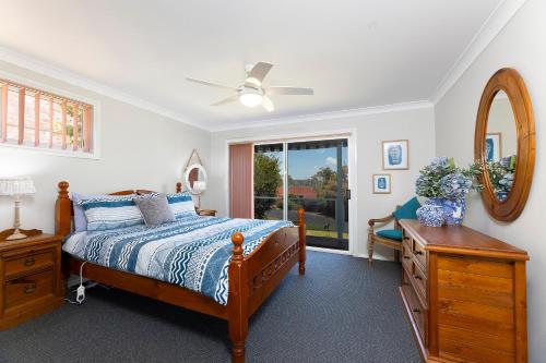 a bedroom with a bed and a dresser and a mirror at Lakeview Lodge in Forster