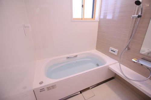 een witte badkamer met een bad en een douche bij Cottage All Resort Service / Vacation STAY 8402 in Inawashiro