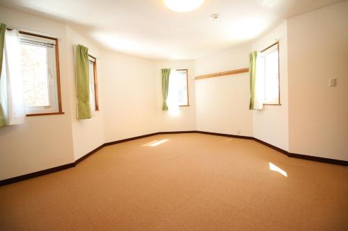 Cottage All Resort Service / Vacation STAY 8402 في Inawashiro: غرفه فاضيه فيها نافذتين وسجاده