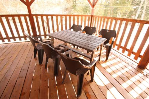 Cottage All Resort Service / Vacation STAY 8402 في Inawashiro: طاولة وكراسي خشبية على سطح خشبي