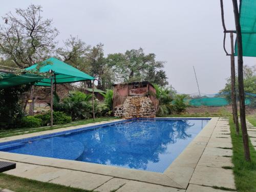 ein Schwimmbad mit einem Zug im Hintergrund in der Unterkunft Cocorico Stay Ya! Cottages Alibag in Alibag