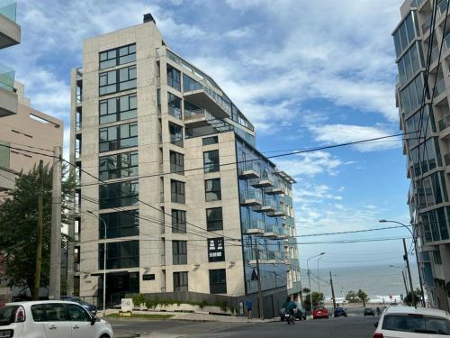 a tall building on a city street with cars at Playa Grande Apartment in Mar del Plata