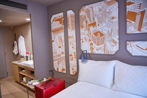 a bedroom with a bed and a bathroom with a sink at lyf Ginza Tokyo in Tokyo