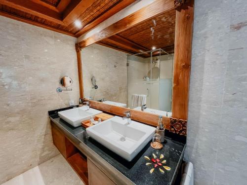 a bathroom with two sinks and a mirror at Sakti Garden Resort & Spa in Ubud