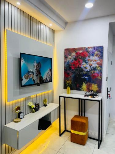 a living room with a tv on a wall at AMERICANA LUXURY APARTMENT in Lekki