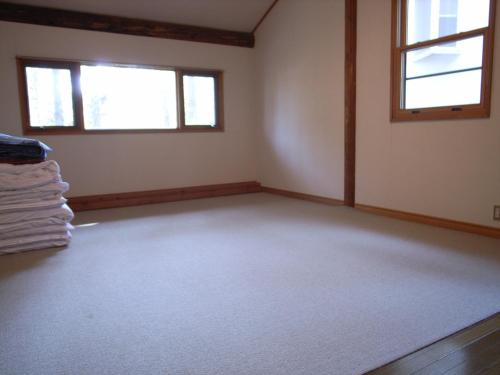 una stanza vuota con due finestre in una stanza di Cottage All Resort Service / Vacation STAY 8424 a Inawashiro