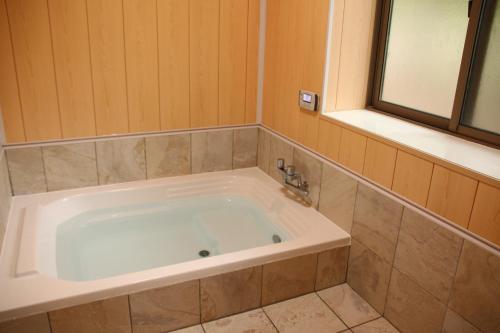 baño con bañera grande y ventana en Cottage All Resort Service / Vacation STAY 8424 en Inawashiro